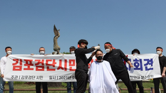 김포·인천 검단지역 시민단체 회원들이 4일 오후 서울 청와대 분수대 앞에서 광역급행철도(GTX) D 노선의 강남 직결과 서울지하철 5호선 김포 연장 등을 촉구하며 삭발을 하고 있다. <연합뉴스>